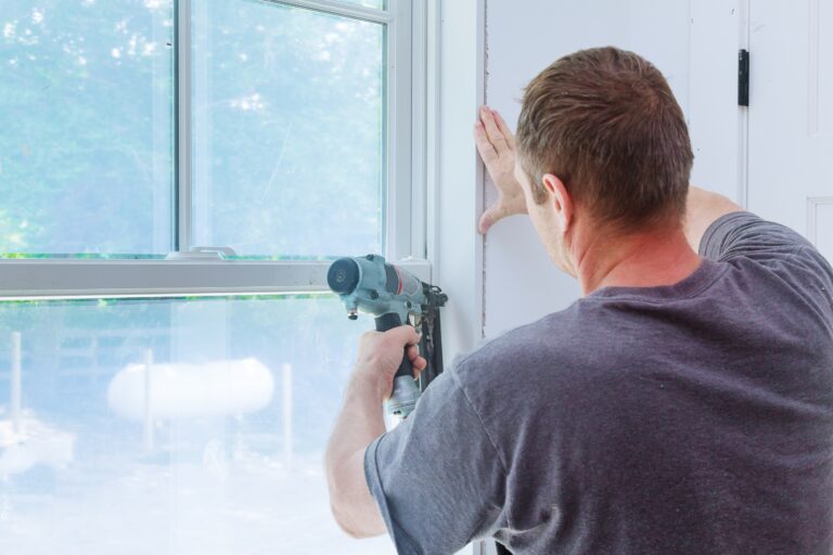 Worker installing trim around a window molding installed moldings materials